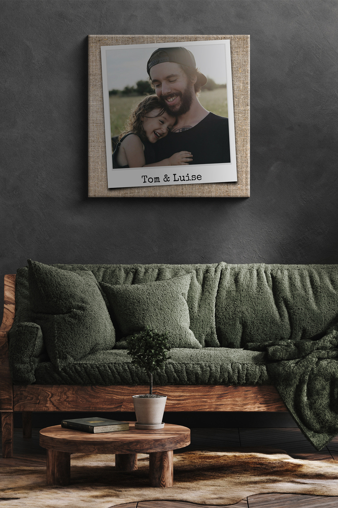 Poster photo père-fille façon photo instantanée avec prénoms, sur un mur gris foncé au-dessus d’un canapé vert