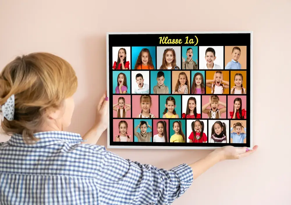Bunte Klassenfoto-Collage im weißen Rahmen an einer hellen Wand als Abschiedsgeschenk für die Lehrerin