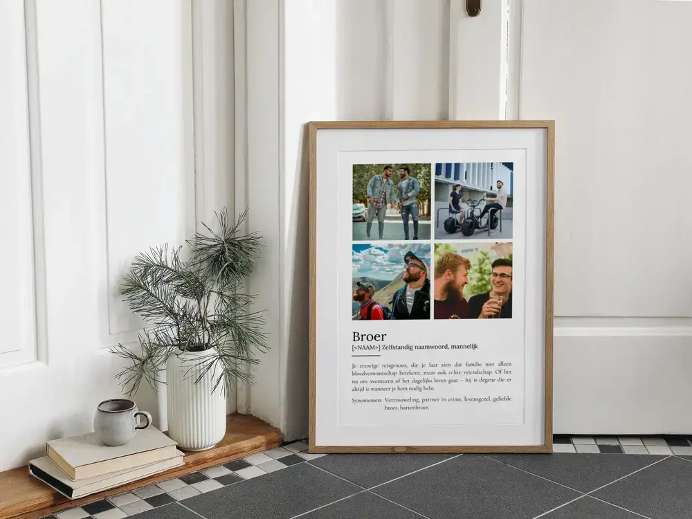 Ingelijste definitieposter met vier foto's op de vloer naast boeken en een plant, een cadeau-idee voor een broer