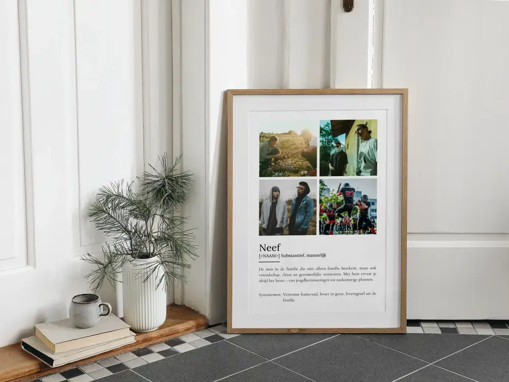 Poster voor een neef met vier foto's en definitietekst, in een houten lijst op de vloer naast een vaas