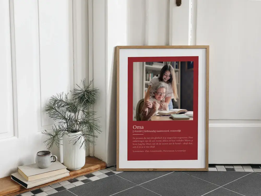 Cadeau-idee voor oma: wijnrode fotoposter met definitie in een houten lijst, op de vloer naast een plant