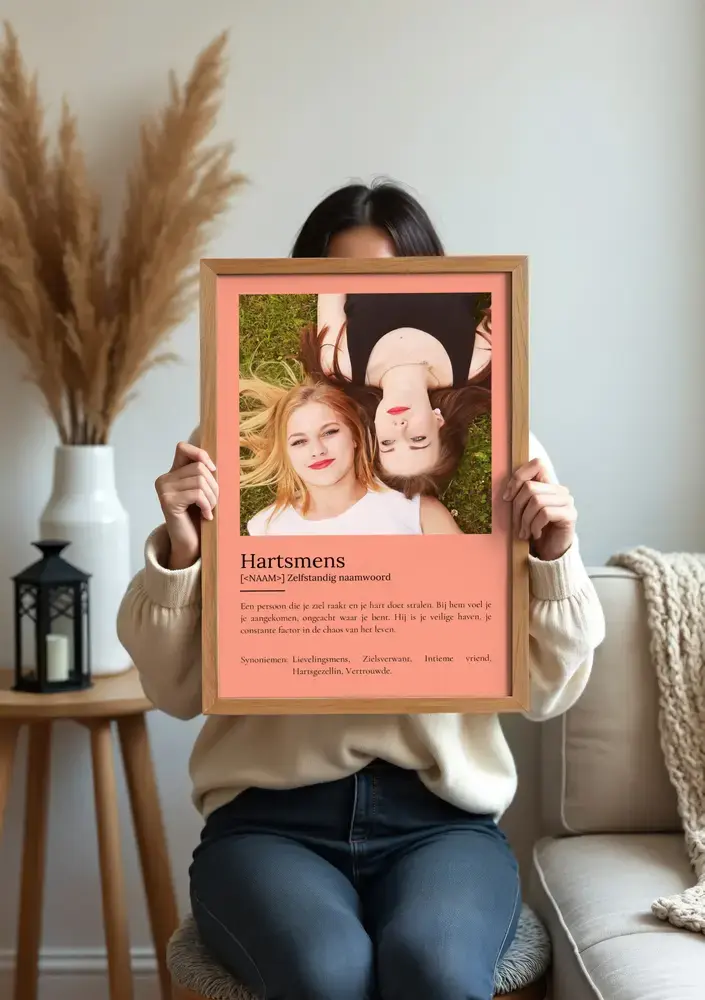 Zalmroze definitieposter met grote vriendinnenfoto en persoonlijke tekst in houten lijst, bij de bank
