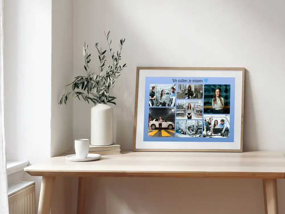 Fotocollage voor het afscheid van een collega, met blauwe achtergrond in een houten lijst op een bureau naast een vaas