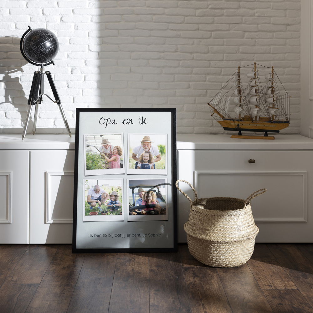 Fotocollage van opa en kleindochter met 4 foto's in retrostijl, in een zwarte lijst op de vloer voor een wit dressoir