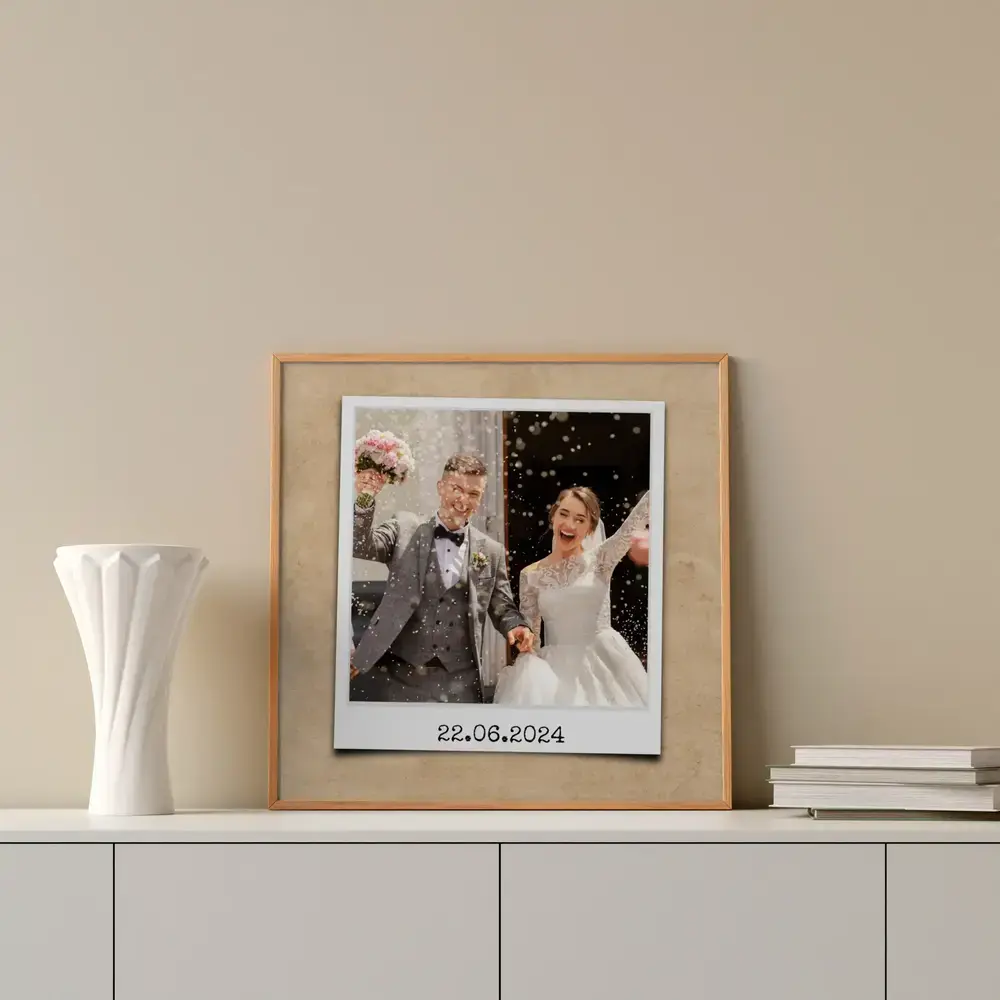 Ingelijste trouwfoto in instantfotostijl met datum, op een wit dressoir naast een vaas