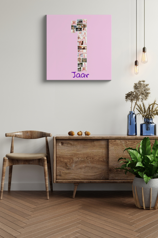 Fotocollage op canvas van het eerste babyjaar, met foto’s als cijfer 1 op roze, boven een houten dressoir