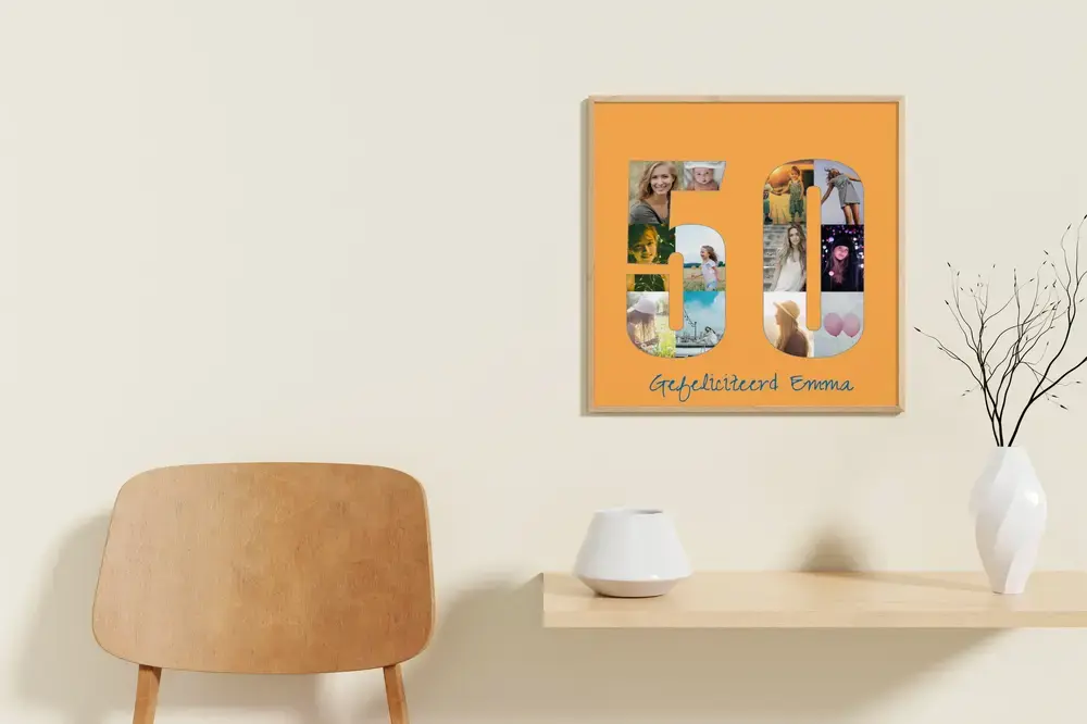 Fotocollage in de vorm van 50 op oranje achtergrond, in houten lijst aan de muur boven een bureau