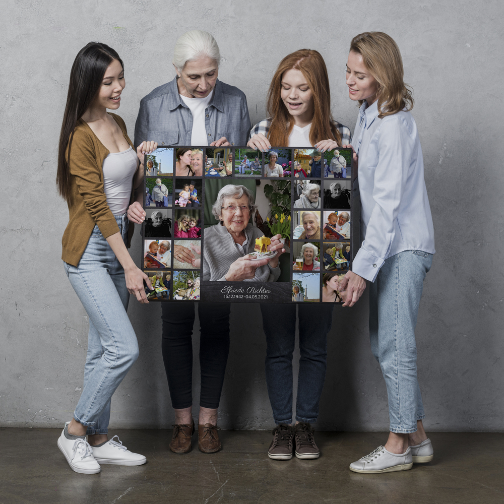 Große Trauercollage mit zentralem Porträt, 24 Erinnerungsfotos und Namensfeld, präsentiert vor grauer Wand