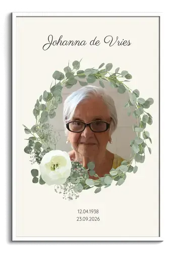 Persoonlijk gedenkportret met naam, eucalyptuskrans en witte bloemen in een witte lijst