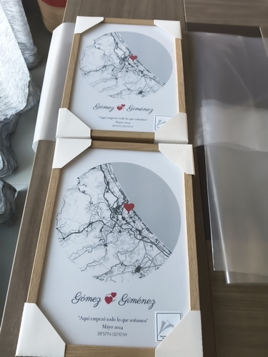 Deux affiches de plans de ville ronds avec un cœur, encadrées en bois naturel sur une table, cadeau romantique